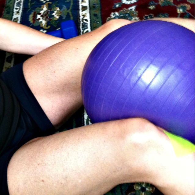 Terapia de dolor de rodilla con fibromialgia usando pelota de ejercicio pequeña.